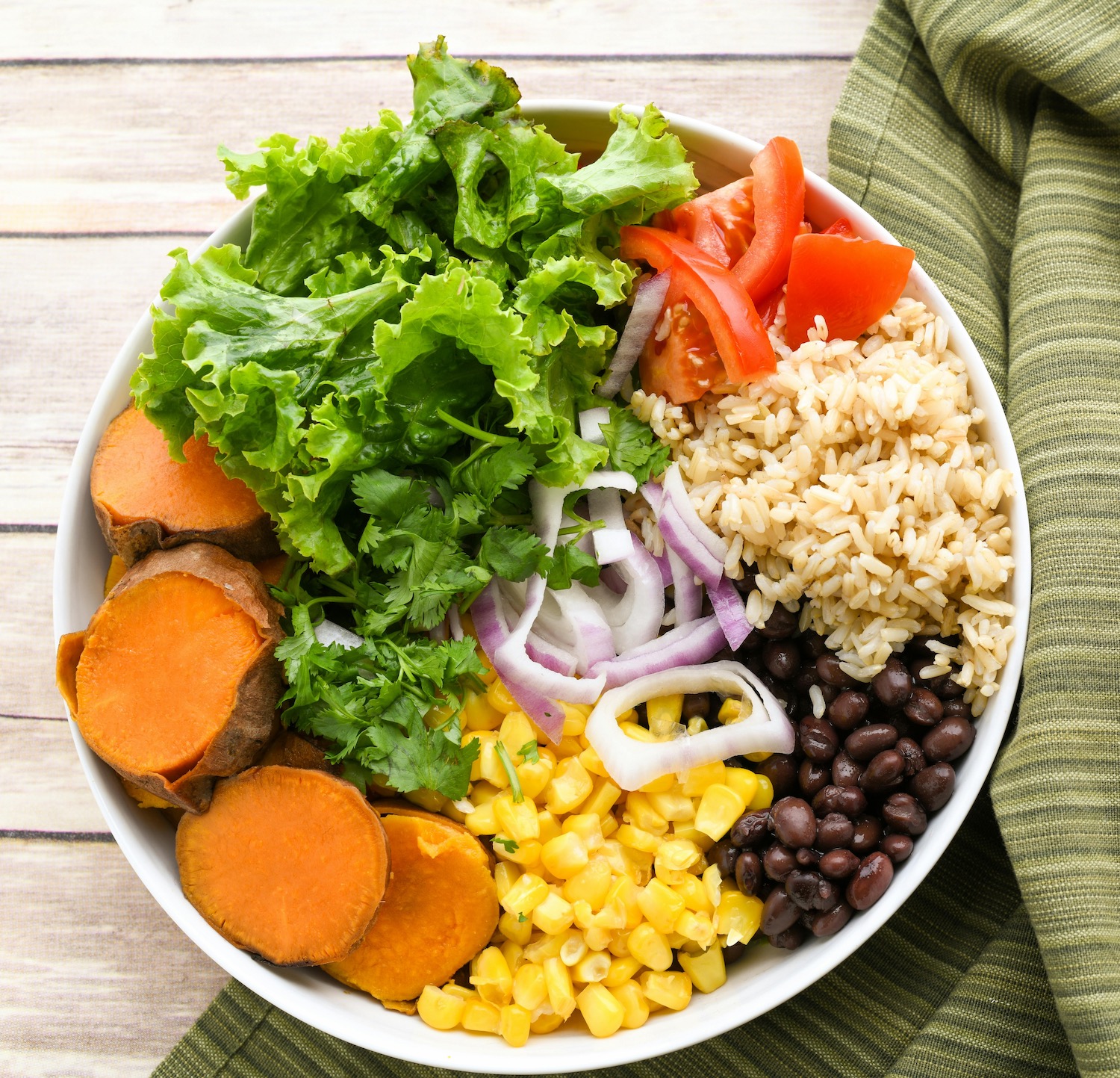 Nourish bowl with brown rice, beans, corn, and vegetables
